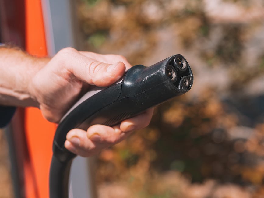 An image of an electric vehicle charging station with a car parked to the side.