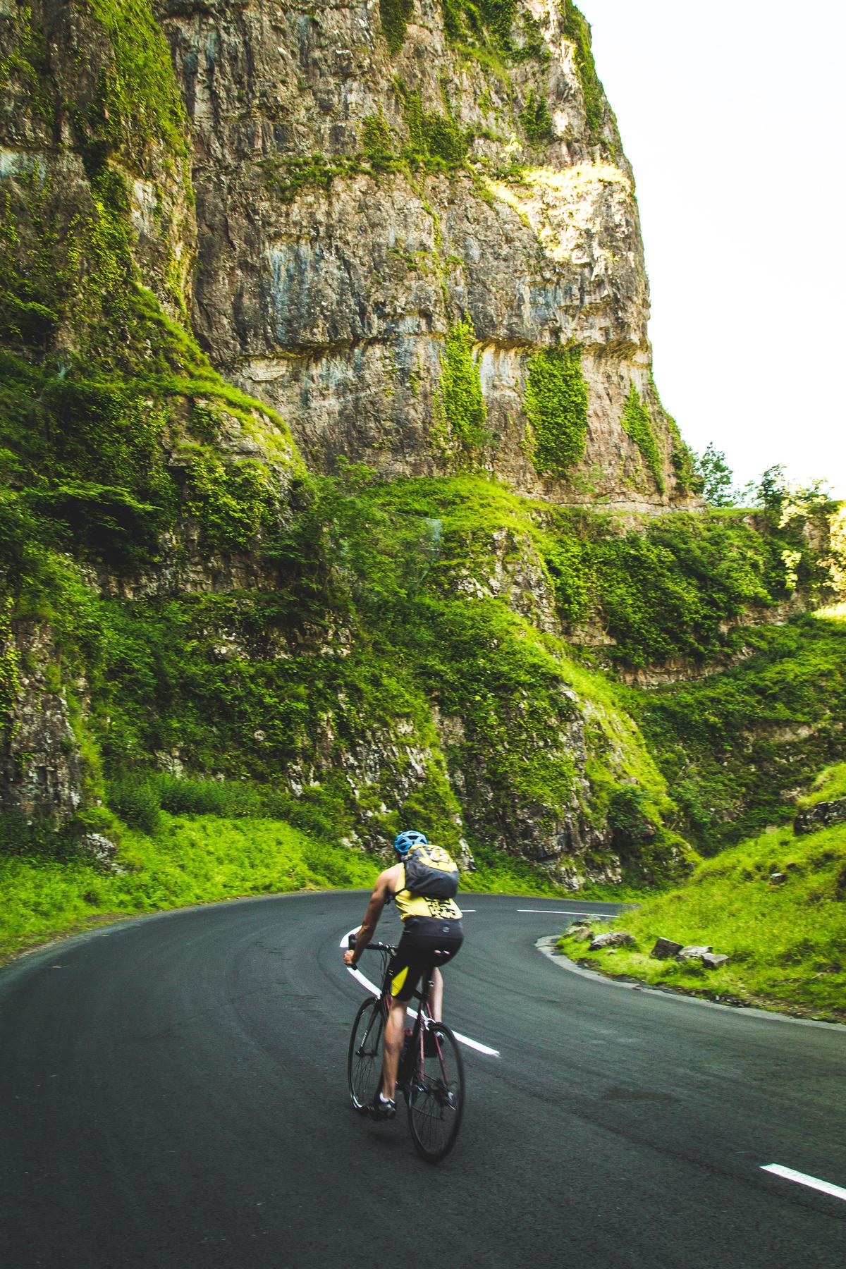 A picture of various pieces of equipment that a mountain biker will need such as a bike, helmet, gloves, shorts, hydration pack, multi-tool, and snacks.